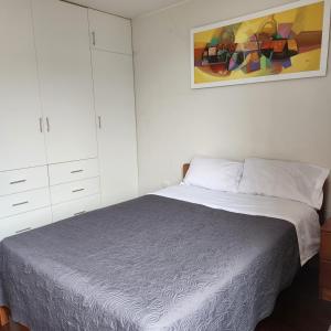 - une chambre avec un lit et une peinture murale dans l'établissement Casa Cultura, à Lima
