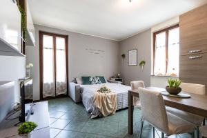 een slaapkamer met een bed en een tafel en stoelen bij [SMART FLAT] Private Garage, Wi-Fi, Netflix in Castelletto sopra Ticino