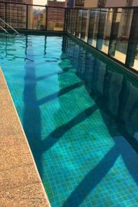a large swimming pool with blue water at Studio APaulistana56 in Sao Paulo