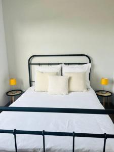 a bed with white sheets and pillows and two lamps at 2 Bedroom, Clutter free in Pretoria
