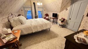 1 dormitorio con cama, escritorio y mesa con TV en The Hancock House Bed & Breakfast Inn en Dubuque