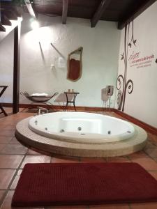 a large bath tub in a room with a red rug at Hotel Boutique Casabella in Coatepec