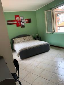 ein Schlafzimmer mit einem Bett in einer grünen Wand in der Unterkunft Garibaldi 26 in Stresa