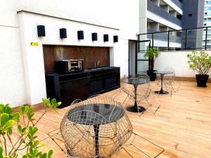 a patio with chairs and tables on a building at Studio APaulistana56 in Sao Paulo