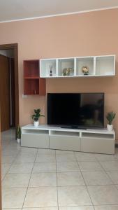 un soggiorno con una grande TV a schermo piatto in una camera di Garibaldi 26 a Stresa