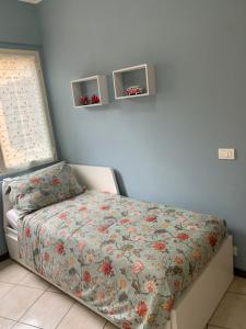 una camera da letto con un letto con copriletto floreale di Garibaldi 26 a Stresa