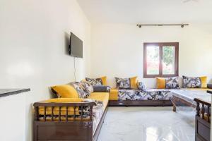 uma sala de estar com um sofá e uma televisão em Appartement chaleureux et calme, Parking, Jardin em Agadir