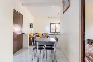 uma cozinha e sala de estar com mesa e cadeiras em Appartement chaleureux et calme, Parking, Jardin em Agadir