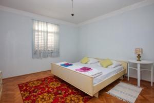 a white bedroom with a bed and a window at Apartments by the sea Tisno, Murter - 21405 in Tisno