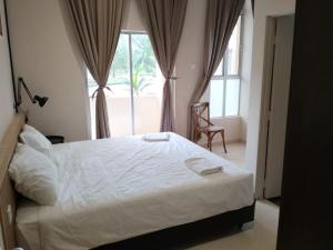 a bedroom with a white bed and a window at Seri Bayu Resort Hotel in Kampong Bagan Lalang