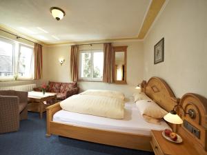 a bedroom with a large bed and a living room at Gasthof Restaurant Bürgerstüble in Sankt Peter
