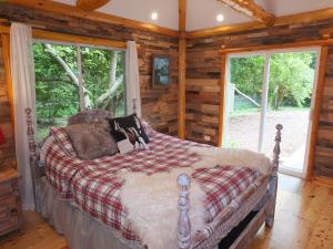 a bedroom with a bed in a log cabin at New! La Maison Malabar - Gorgeous Luxury Cabin! in South Haven