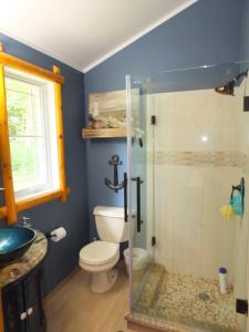 a bathroom with a toilet and a shower at New! La Maison Malabar - Gorgeous Luxury Cabin! in South Haven