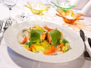ein weißer Teller mit Lebensmitteln auf einem Tisch in der Unterkunft Gasthof Restaurant Bürgerstüble in Sankt Peter