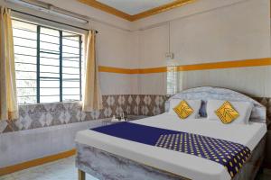 a bedroom with a bed and a large window at OYO Torna Lodge in Pune