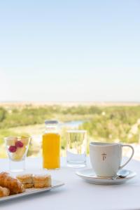 una mesa con un plato de comida y una taza de zumo de naranja en Parador de Ciudad Rodrigo, en Ciudad Rodrigo