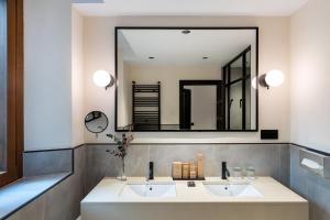 Un baño con dos lavabos y un espejo grande. en Parador de Ciudad Rodrigo, en Ciudad Rodrigo