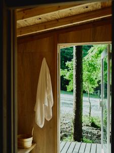 una toalla blanca colgada en una pared junto a una puerta en 湖畔を一望するプライベートホテル / THE [] TIME FUJI, en Fujikawaguchiko
