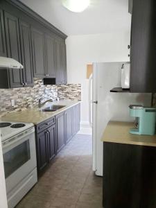 een keuken met een wit fornuis en een witte koelkast bij BlueBack BeachFront 2-Bedroom Private Apartment in Nanaimo