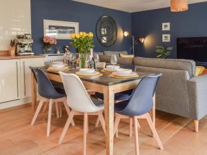 a dining room and living room with a table and chairs at Bluebell Barn in Grampound