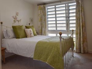 a bedroom with a bed and a large window at Bluebell Barn in Grampound