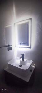 baño con lavabo con luz encendida en Departamento Cochabamba en Cochabamba