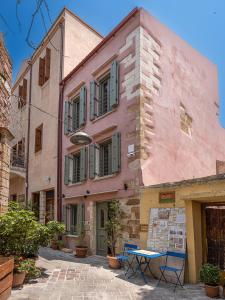 a pink building with a table in front of it at Theros Home in Chania