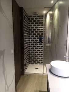 a bathroom with a white sink and a brick wall at BrandApartments in Porto