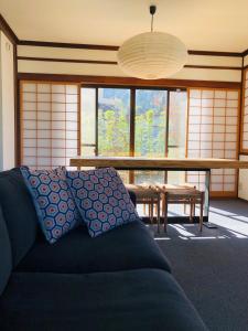 uma sala de estar com um sofá e uma mesa em NIKONOS III em Nozawa Onsen