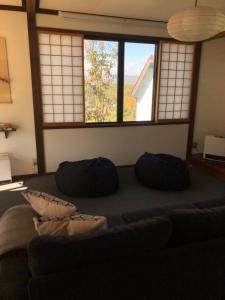 uma sala de estar com um sofá e duas janelas em NIKONOS III em Nozawa Onsen
