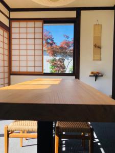 a large wooden table in a room with a window at NIKONOS III in Nozawa Onsen
