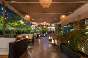 a restaurant with tables and chairs and potted plants at Best Western Premier Marina Las Condes in Santiago
