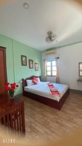 - une chambre avec un grand lit et une table dans l'établissement Villa Thavisouk Legend - Luang Prabang, à Luang Prabang