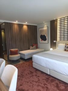 um quarto de hotel com duas camas e uma cadeira em BrandApartments no Porto