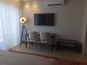 Habitación con mesa con sillas y TV de pantalla plana. en BrandApartments, en Oporto