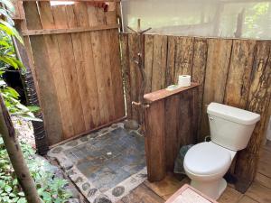 a bathroom with a toilet and a wooden door at Konsenda Bocas del Toro in Bocas del Toro