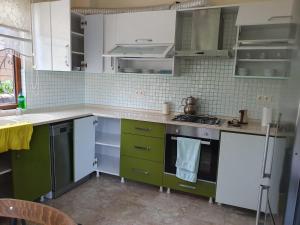 a kitchen with green and white cabinets and a sink at grand1 guests house in Trabzon