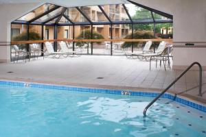a swimming pool in front of a building with a conservatory at Courtyard by Marriott Lexington North in Lexington