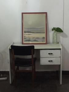 escritorio con silla y una foto en la pared en Casa Victoria en Saavedra amoblada en Buenos Aires