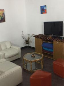 sala de estar con sofá y TV de pantalla plana en Casa Victoria en Saavedra amoblada en Buenos Aires