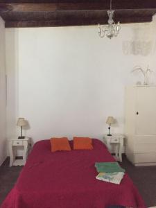 1 dormitorio con 1 cama de color púrpura y 2 mesitas de noche en Casa Victoria en Saavedra amoblada en Buenos Aires