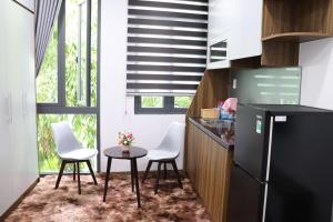 a kitchen with two chairs and a table and a refrigerator at Moon Apartment in Ho Chi Minh City