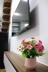 a pink vase filled with pink flowers on a table at Moon Apartment in Ho Chi Minh City