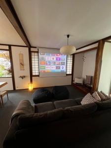 a living room with a couch and a large screen at NIKONOS III in Nozawa Onsen