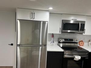 a kitchen with a stainless steel refrigerator and a microwave at 2-bedroom basement apartment in Calgary