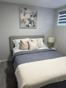 a bedroom with a large bed with pillows on it at 2-bedroom basement apartment in Calgary