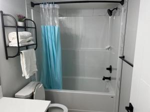 a bathroom with a shower and a white toilet at 2-bedroom basement apartment in Calgary +40 photos