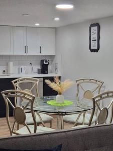 a dining room with a glass table and chairs at 2-bedroom basement apartment in Calgary