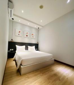 una camera da letto con un grande letto bianco di oxy suites 1-03 at Shop House Meisterstadt Pollux Habibie a Batam Center