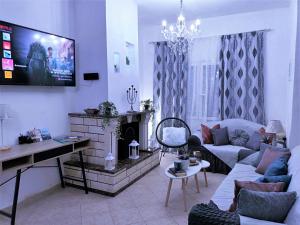 a living room with a couch and a tv at Casa di Helena Luxury villa Corfu in Antipernoí